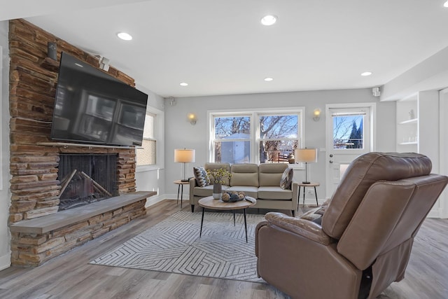 living area with baseboards, a fireplace, wood finished floors, and recessed lighting