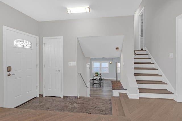 entrance foyer with stairway, baseboards, and wood finished floors