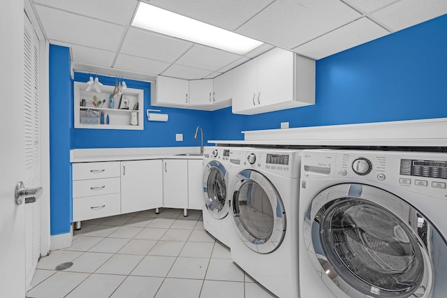 laundry area featuring cabinet space, light tile patterned floors, a sink, and independent washer and dryer