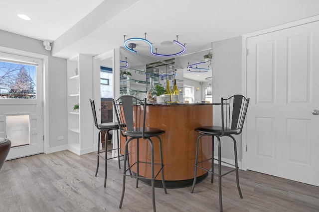 bar featuring a dry bar, baseboards, and wood finished floors