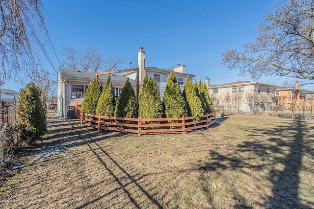 exterior space featuring a yard, fence, and central air condition unit