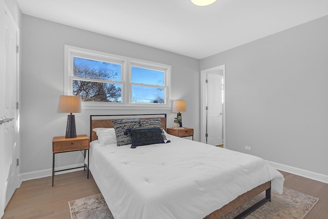 bedroom featuring wood finished floors and baseboards