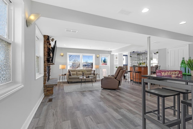 living area featuring recessed lighting, wood finished floors, visible vents, and baseboards