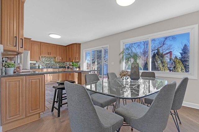 dining space with light wood-style floors and baseboards