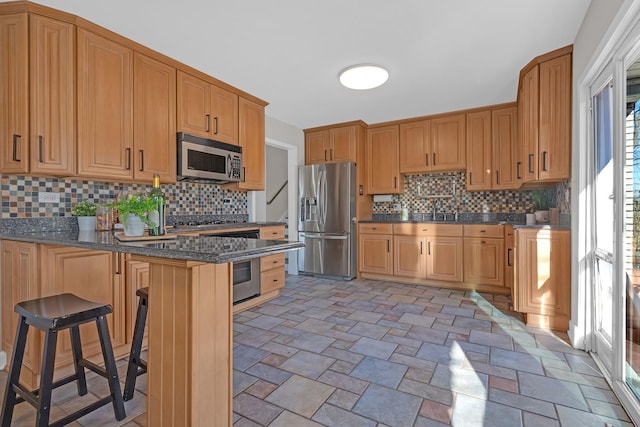 kitchen with stainless steel appliances, backsplash, a peninsula, and a breakfast bar area