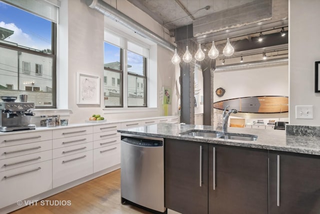 kitchen with light wood finished floors, stainless steel dishwasher, white cabinetry, a sink, and modern cabinets