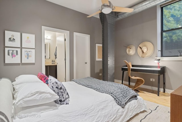 bedroom featuring ensuite bathroom, ceiling fan, baseboards, and wood finished floors