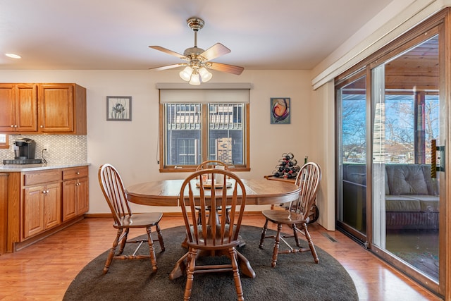 dining room with ceiling fan, baseboards, and light wood-style floors