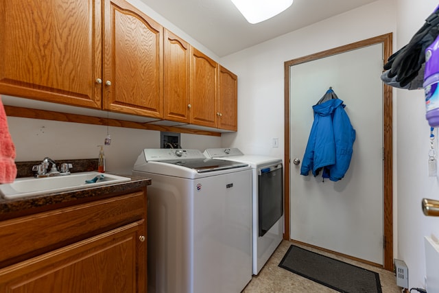 laundry room with cabinet space, washer and clothes dryer, and a sink