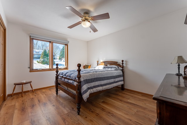 bedroom featuring light wood-type flooring, baseboards, and a ceiling fan