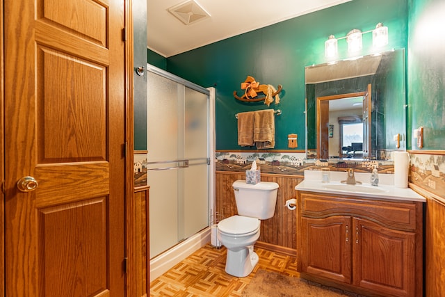 full bathroom with toilet, a shower stall, vanity, and wainscoting