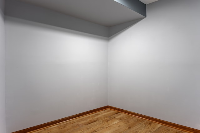 unfurnished room with light wood-type flooring and baseboards