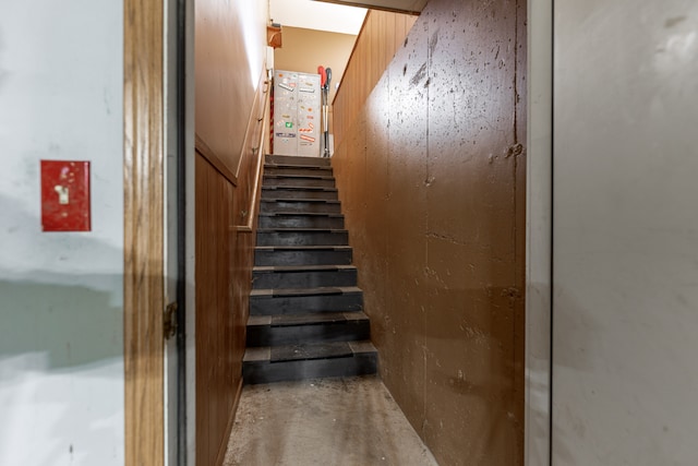 stairs featuring concrete flooring