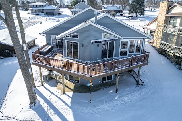 snow covered back of property featuring a wooden deck