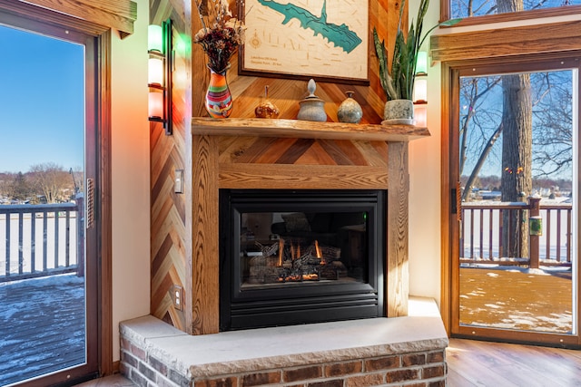 room details with a lit fireplace and wood finished floors