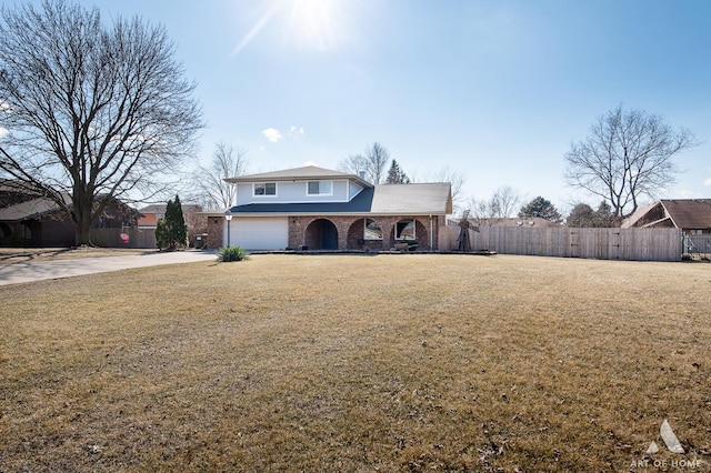 traditional-style home featuring brick siding, a front lawn, fence, concrete driveway, and a garage