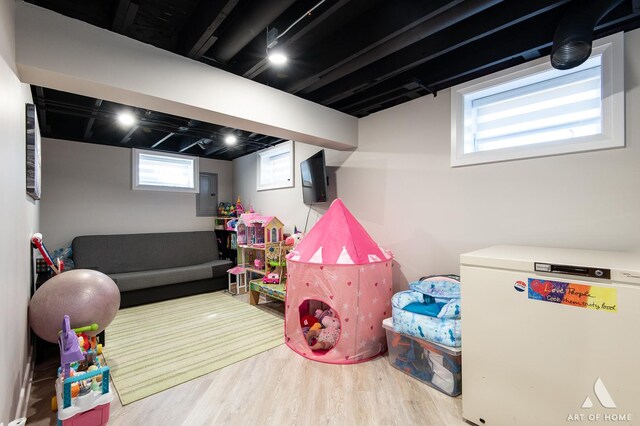 game room with electric panel and wood finished floors