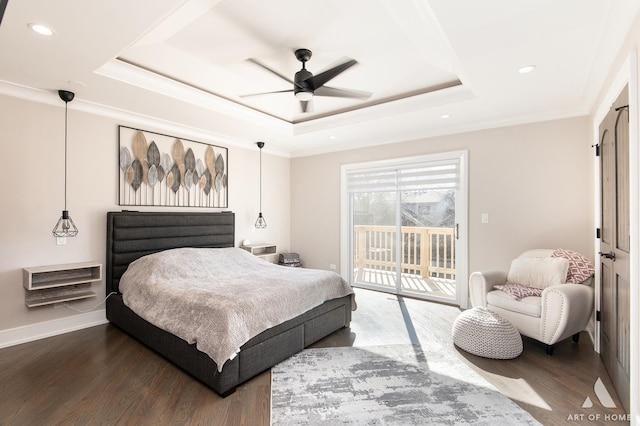 bedroom with a tray ceiling, wood finished floors, access to exterior, and ornamental molding