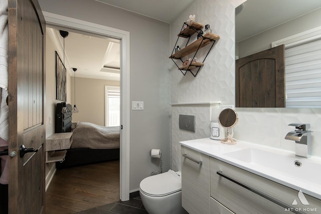 ensuite bathroom with tile patterned floors, toilet, ensuite bathroom, crown molding, and vanity