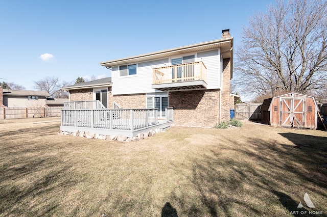 back of house with fence, a shed, an outdoor structure, a lawn, and brick siding