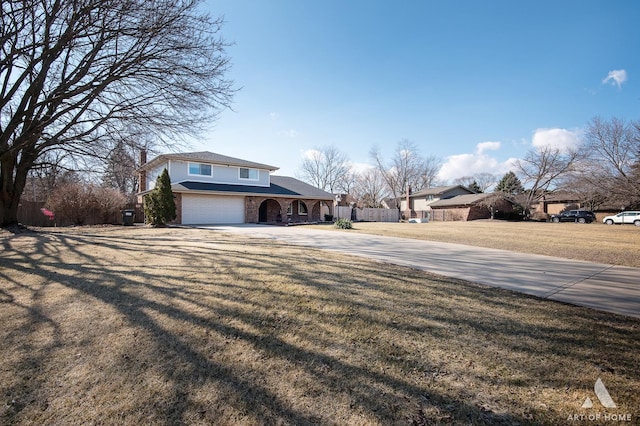 view of front of home with brick siding, fence, concrete driveway, a front yard, and a garage