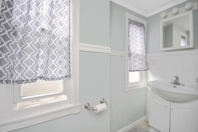 bathroom with tile walls, vanity, and crown molding