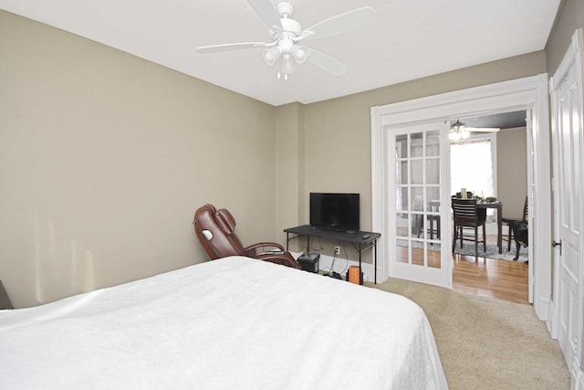 bedroom featuring a ceiling fan, carpet flooring, and french doors