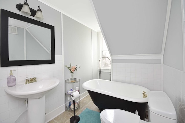 full bath with tile patterned flooring, tile walls, toilet, and a freestanding bath