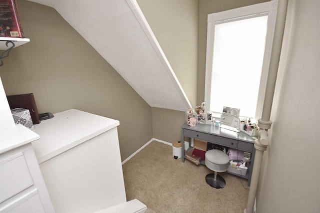 carpeted office featuring baseboards and vaulted ceiling