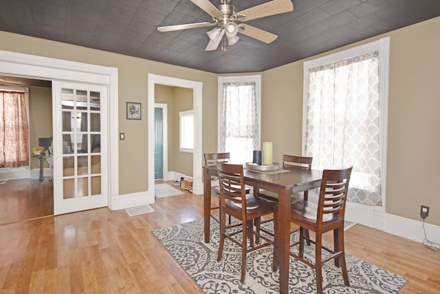 dining area featuring baseboards, wood finished floors, and a ceiling fan