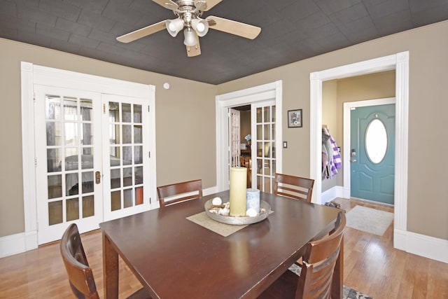 dining space featuring ceiling fan, french doors, baseboards, and wood finished floors