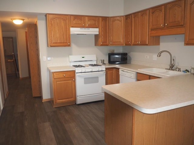 kitchen with white appliances, brown cabinetry, a sink, and under cabinet range hood