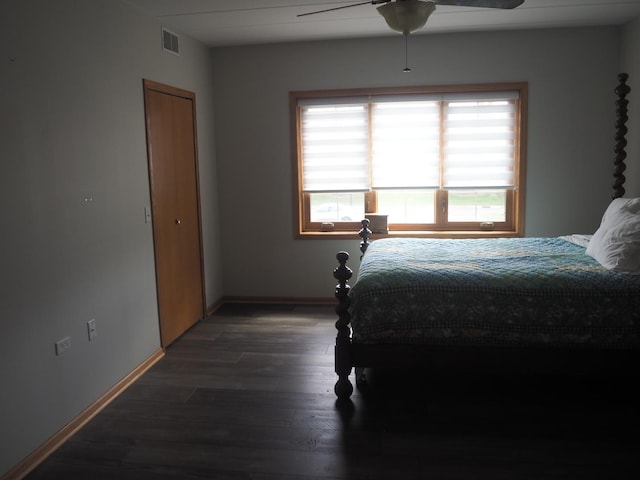 bedroom featuring visible vents, ceiling fan, baseboards, and wood finished floors