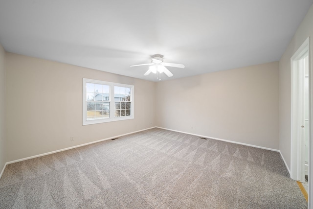 carpeted empty room featuring a ceiling fan and baseboards