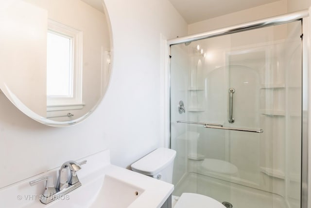 full bathroom featuring vanity, a shower stall, and toilet