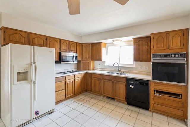 kitchen featuring a sink, black appliances, brown cabinetry, and light countertops