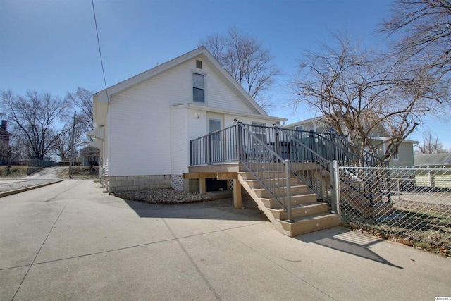 rear view of property featuring fence, a deck, and stairs