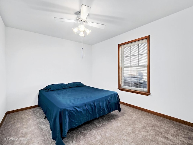 carpeted bedroom with ceiling fan and baseboards