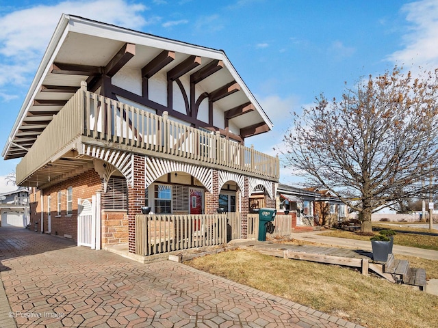 view of front of house with a balcony and brick siding