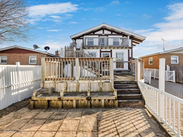 rear view of property with fence and a wooden deck