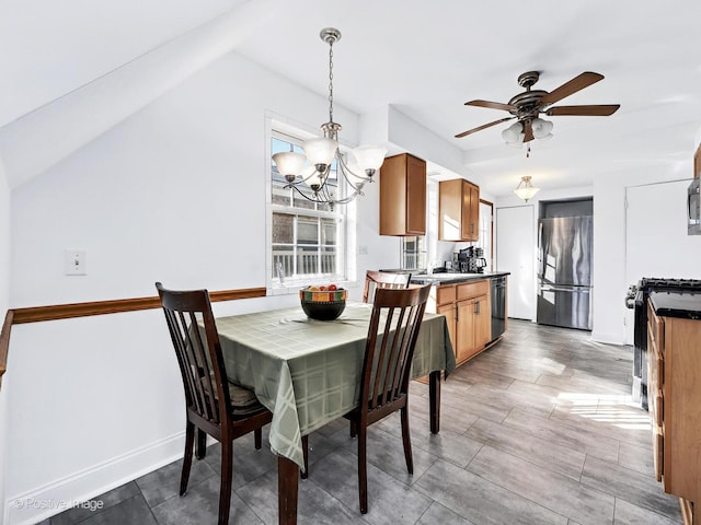 dining area featuring ceiling fan with notable chandelier and baseboards