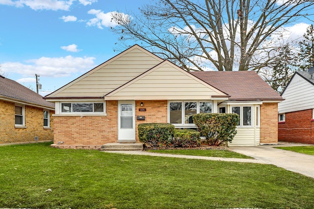 view of front of home featuring a front yard, brick siding, and entry steps