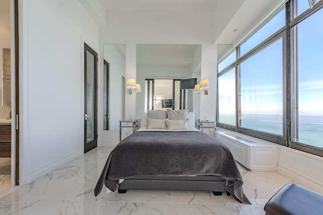 bedroom with baseboards, marble finish floor, and a water view