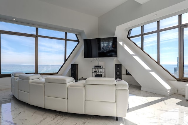 living area featuring a wealth of natural light and marble finish floor