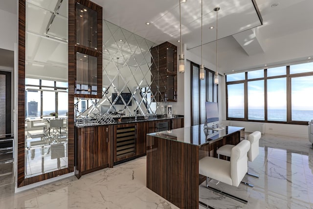 kitchen with dark countertops, marble finish floor, modern cabinets, and beverage cooler