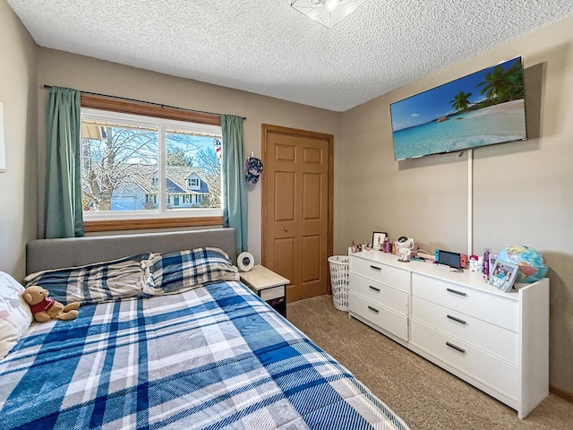 bedroom featuring light carpet and a textured ceiling