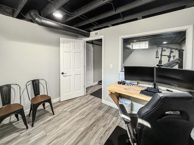 office area featuring baseboards, visible vents, and light wood finished floors