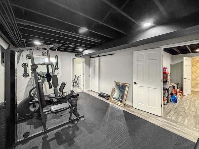 exercise room featuring wood finished floors and a barn door