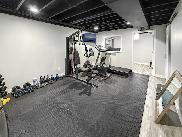 workout area featuring baseboards and wood finished floors