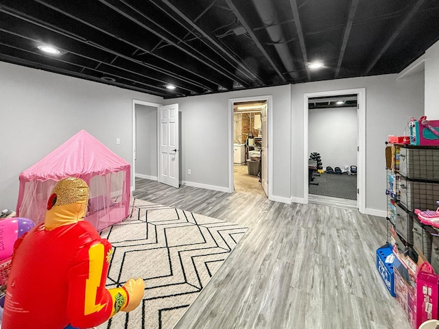 recreation room featuring baseboards and wood finished floors